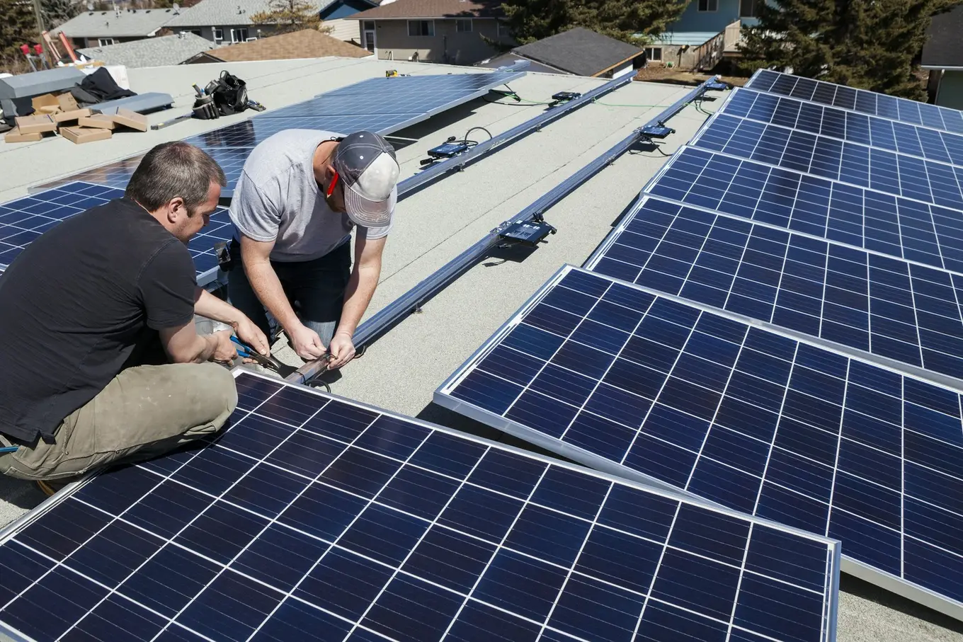 dwóch mężczyzn montuje panele fotowoltaiczne na dachu